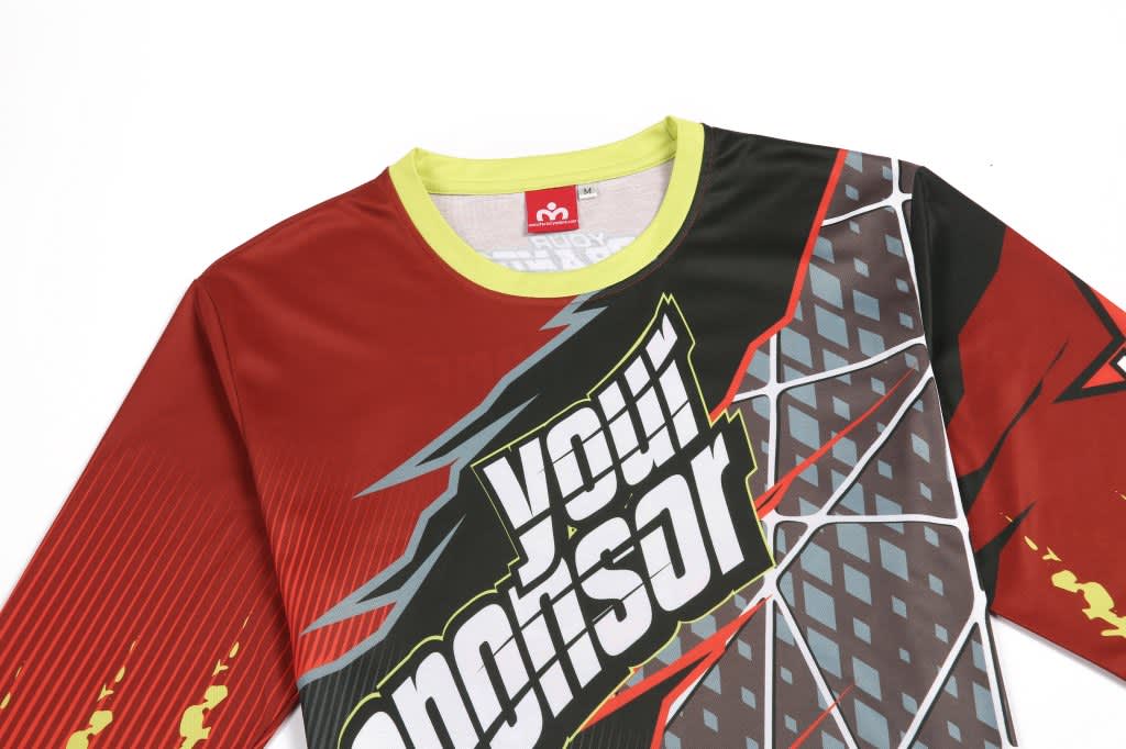 A long-sleeve BMX jersey in red and black with a geometric design and a branded logo on the front.