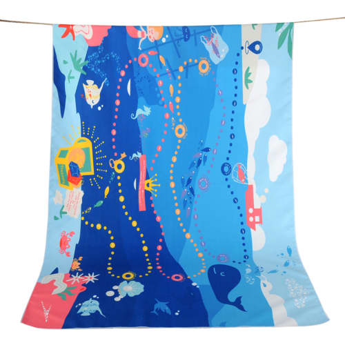 A blue double-faced pile beach towel featuring playful ocean-themed graphics and a vibrant design.