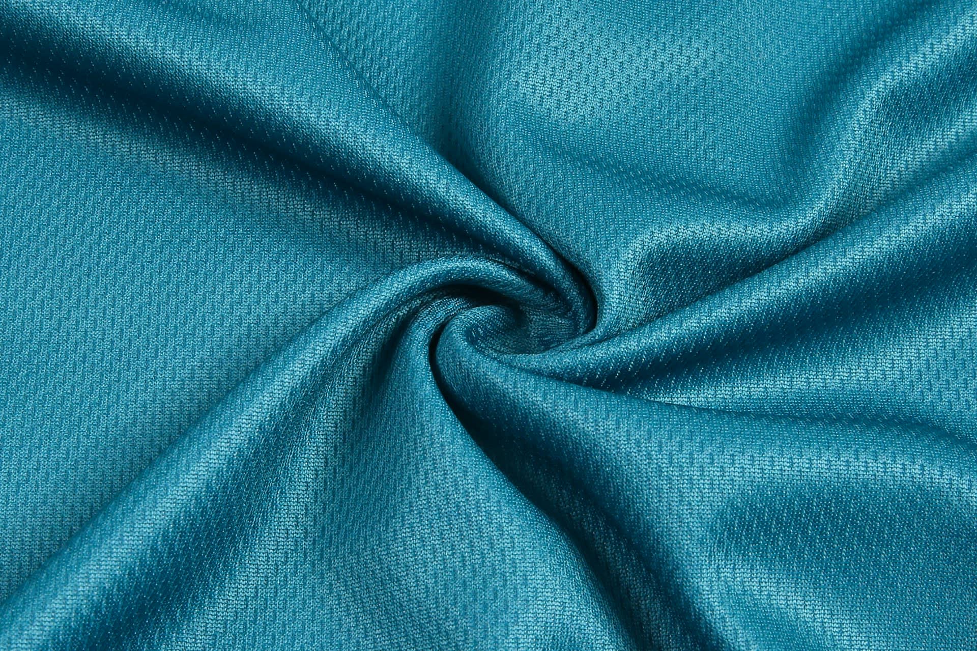 A textured fabric in a vibrant teal colour, showcasing a smooth, soft surface.