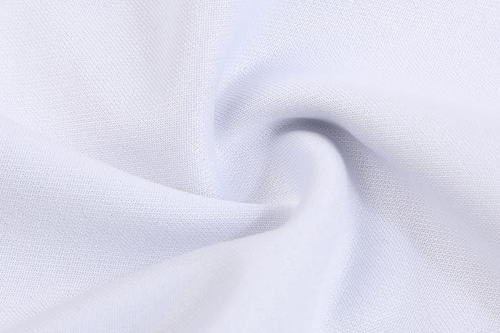 A soft, white fabric with a smooth texture, featuring a slight sheen and a twist in the material.