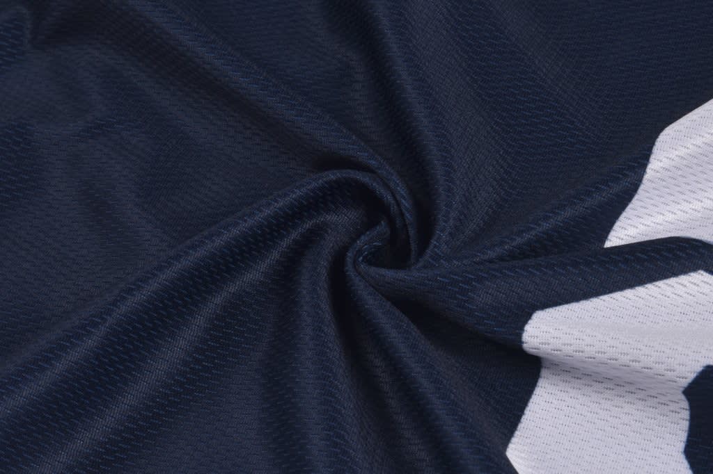 A navy baseball vest featuring a textured fabric with a white logo design. It has a branded logo present.