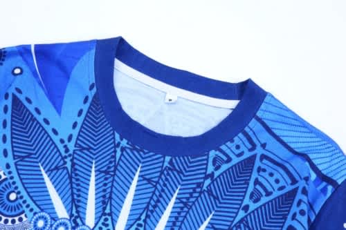A blue Aboriginal cotton t-shirt featuring intricate patterns and designs, with a round neckline and short sleeves.