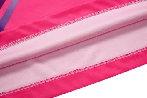 A close-up of a pink sports uniform fabric with stitching detail, featuring a smooth texture and vibrant hues.