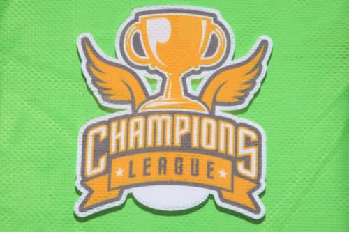 A green promotional bib featuring a logo with a trophy and wings, labelled "Champions League."