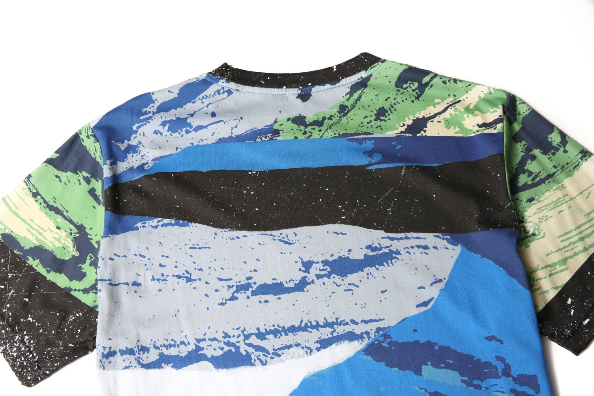 A custom-made printing cotton tee featuring a multicoloured abstract design with blue, green, and black patterns.
