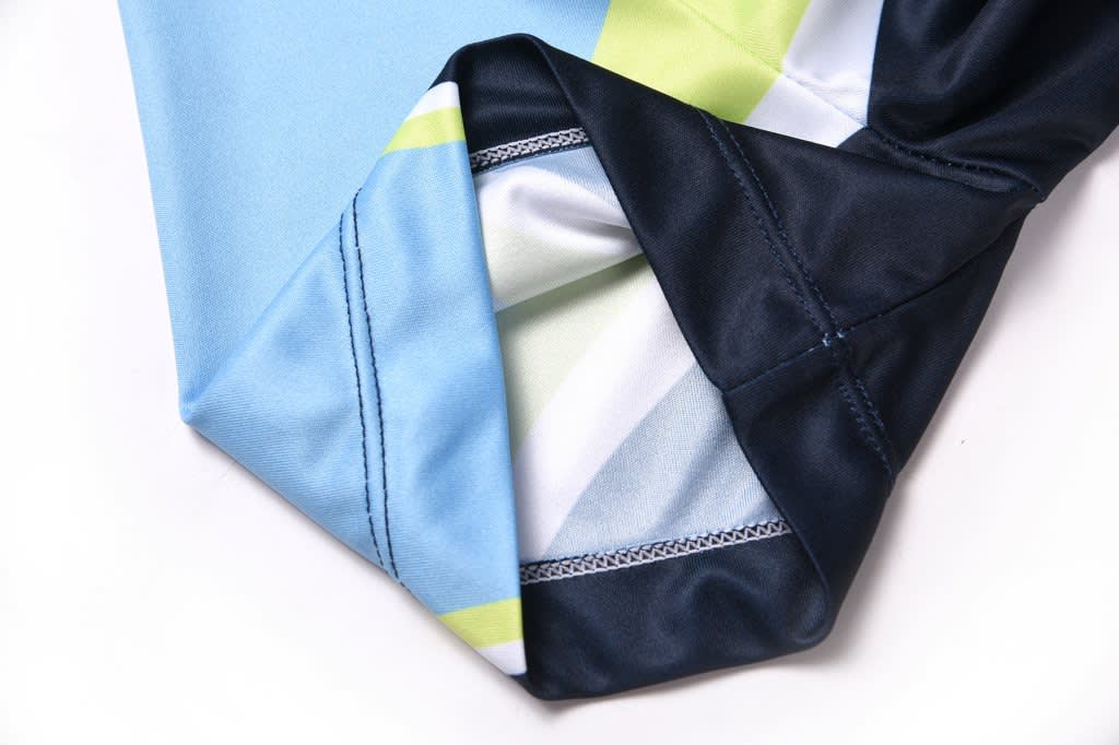 A fabric item featuring blue and navy sections with green and white patterns, showcasing stitched edges and seams.