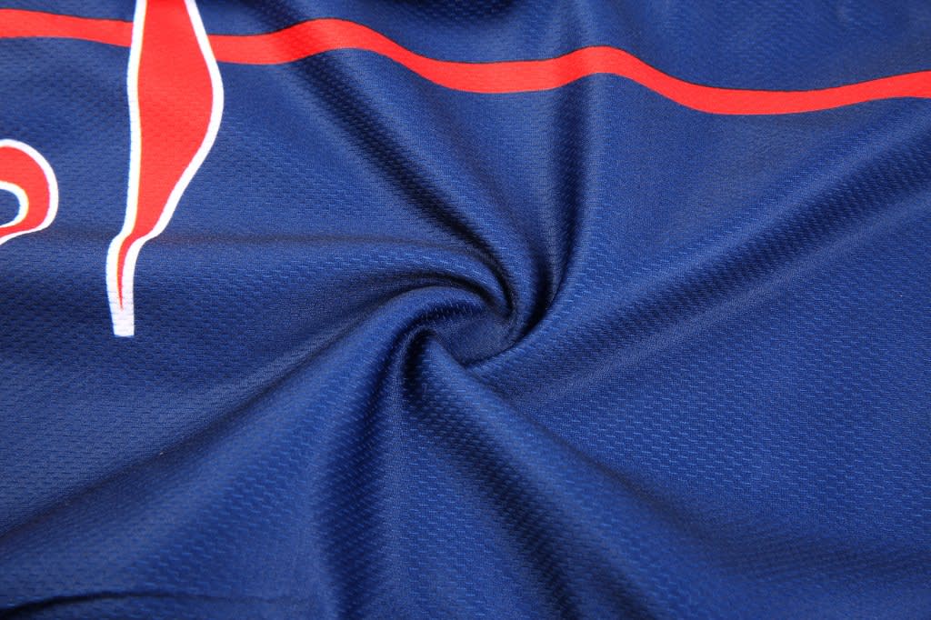 A navy blue fabric with a textured pattern and red accents, featuring a logo on the material.