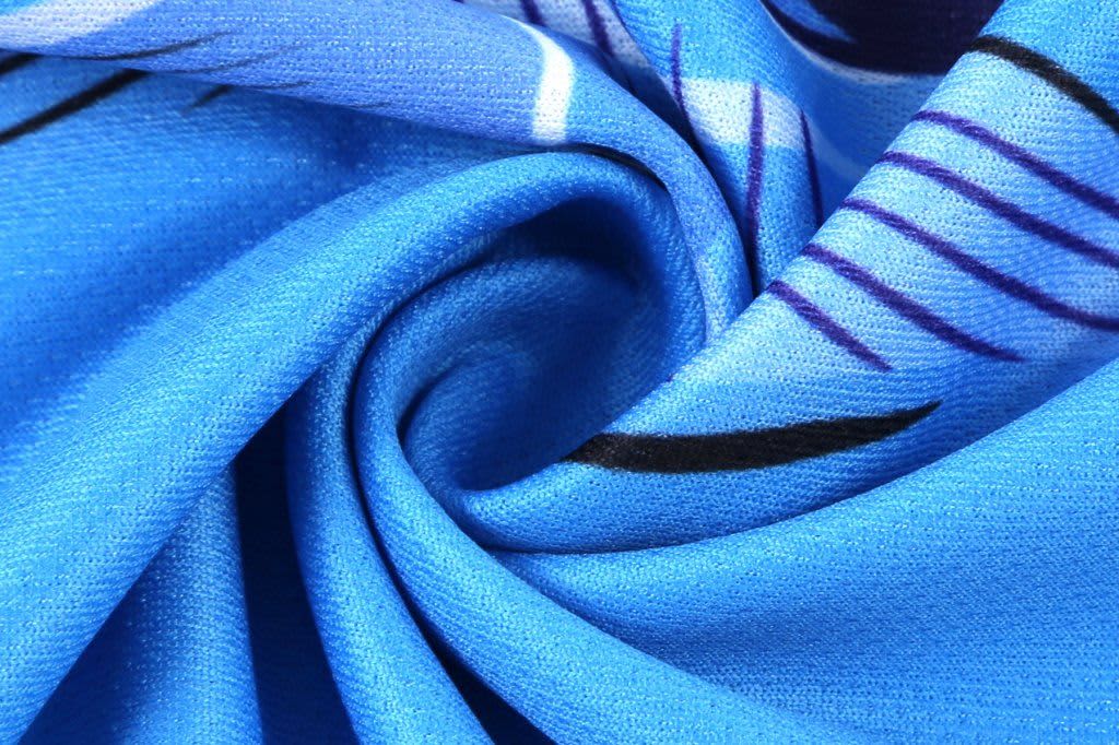 A close-up of blue fabric with a swirling pattern, featuring shades of blue and hints of black and white.