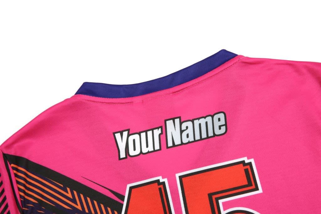 A pink BMX T-shirt featuring a vibrant design, with a placeholder for personalisation and a logo on the fabric.