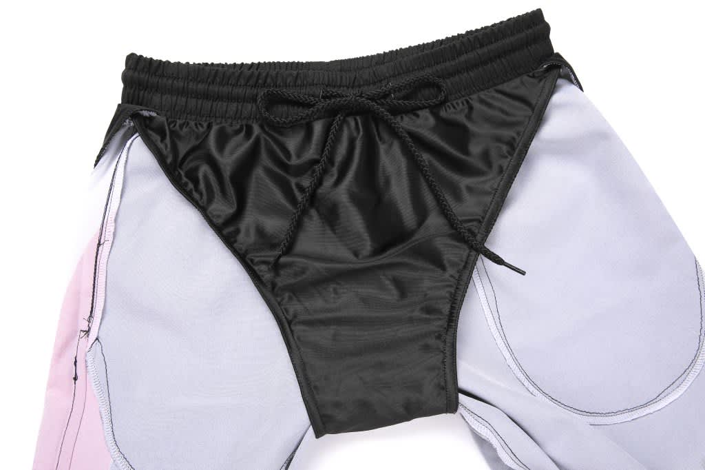 Woven long shorts featuring a black waistband and a combination of light grey and pink fabric.