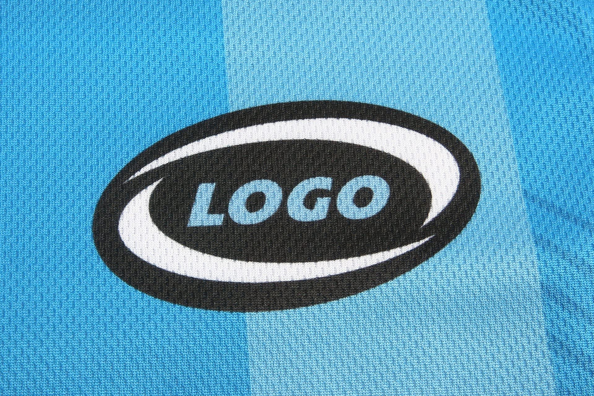 A blue sports uniform featuring a logo on a textured fabric. The uniform has a striped design.