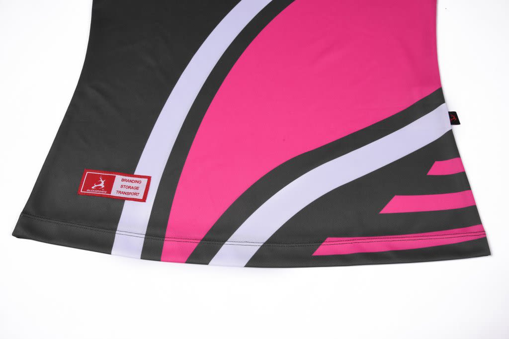 A sublimated polo featuring a black and pink design with curved patterns and a logo on the hem.