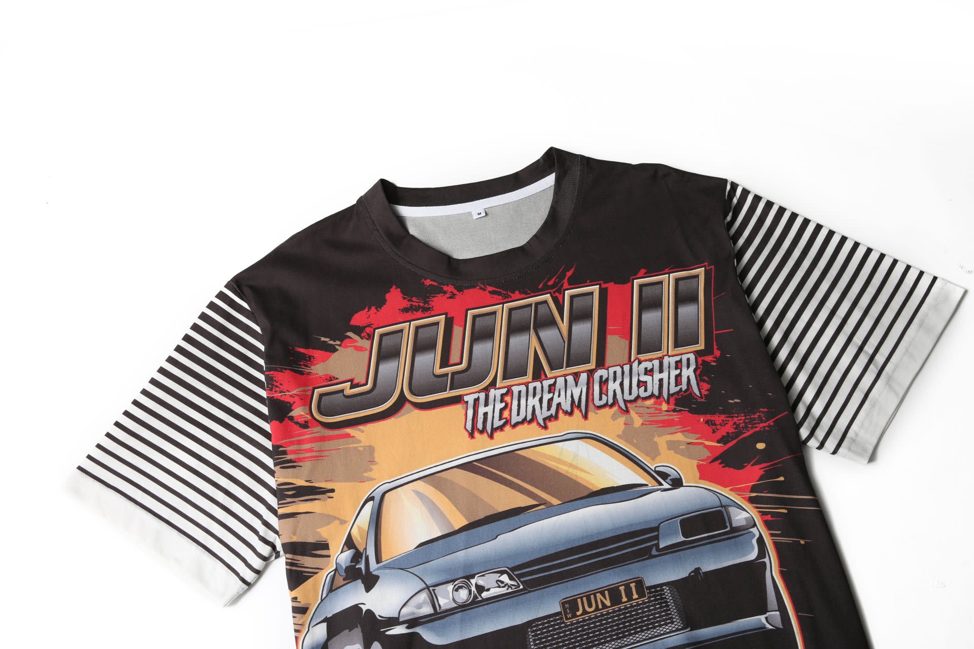 A black and white striped T-shirt featuring a graphic of a car with vibrant red and yellow accents.