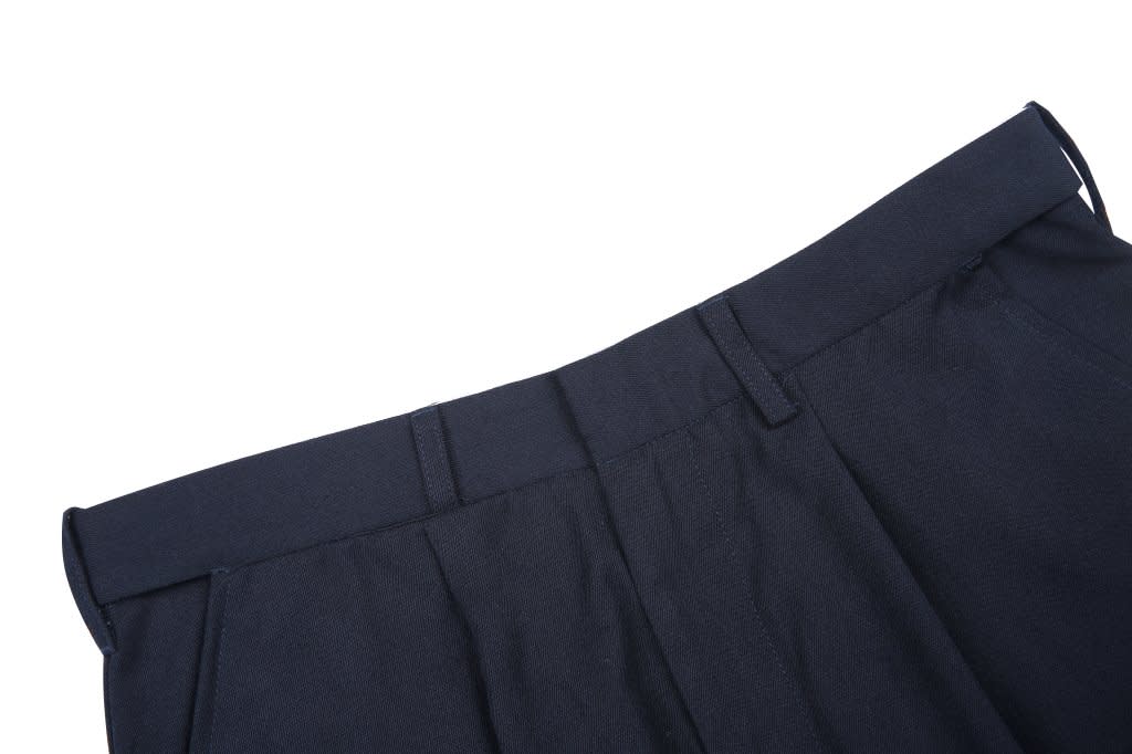 A navy lawn bowling uniform with a flat waistband and tailored design, featuring pockets and a logo.