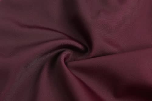 A smooth, maroon fabric with a slight sheen, twisted in a circular pattern.