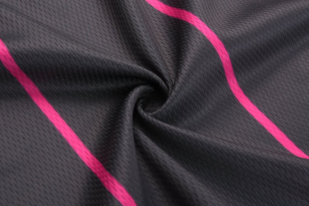 A black fabric featuring a textured pattern with vibrant pink stripes. It has a smooth, flowing appearance.
