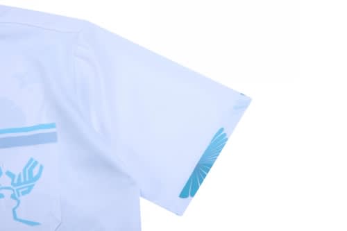 A white shirt featuring blue designs on the sleeve and a logo on the front.