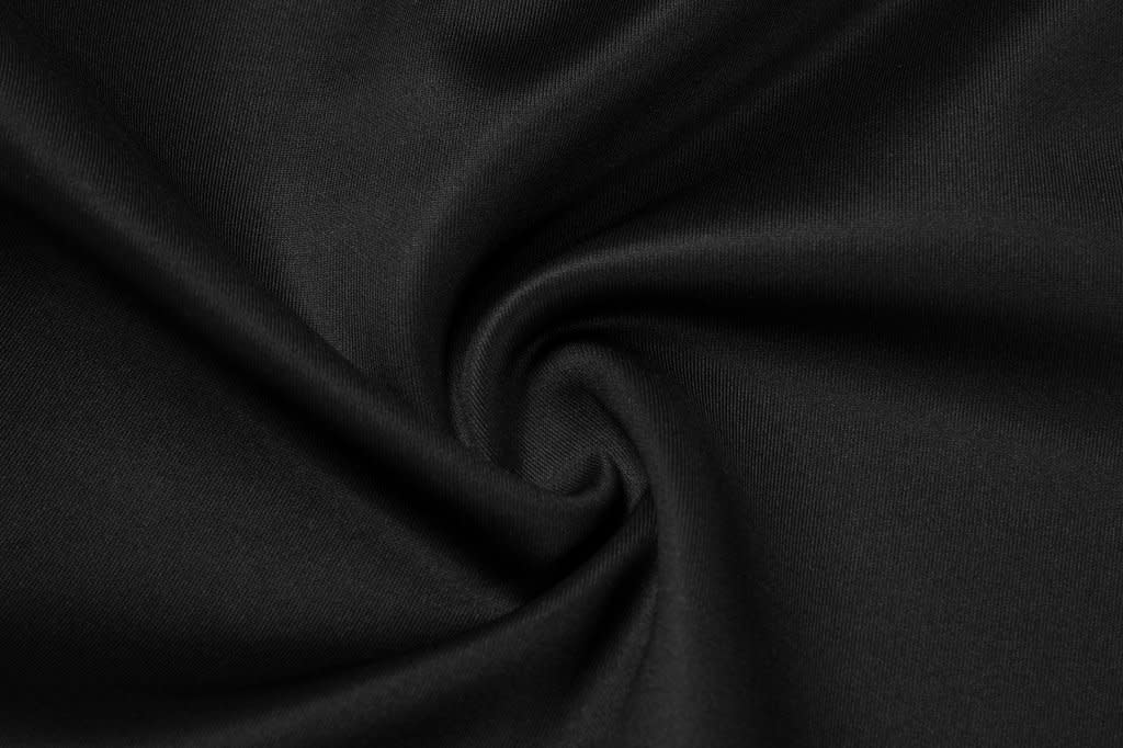 A close-up of black fabric, displaying a smooth, swirling texture with a subtle sheen.