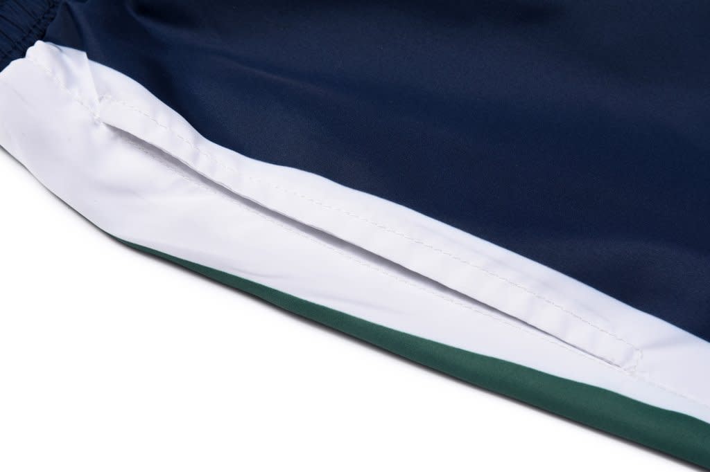A close-up view of a navy blue sports uniform with white and green accents, featuring a logo on the side.