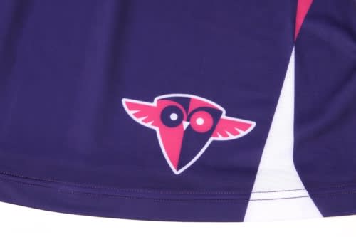 A purple sports uniform with a stylised logo featuring two eyes and wings in red and black.
