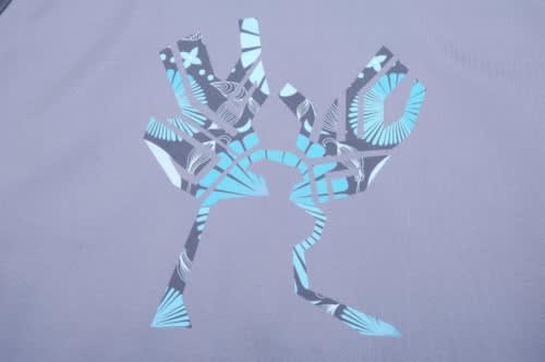 A grey sports jumper featuring a stylised design in blue tones and a logo.
