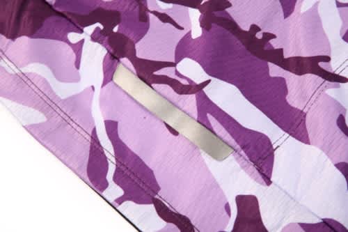 A close-up of a purple camouflage fabric, featuring a plain label area without text.