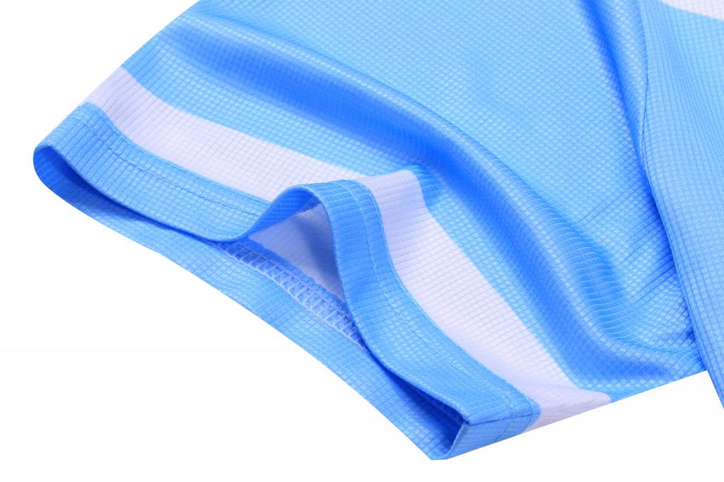 A blue mini waffle tee with a textured pattern and white detailing on the sleeves. It features a branding logo.