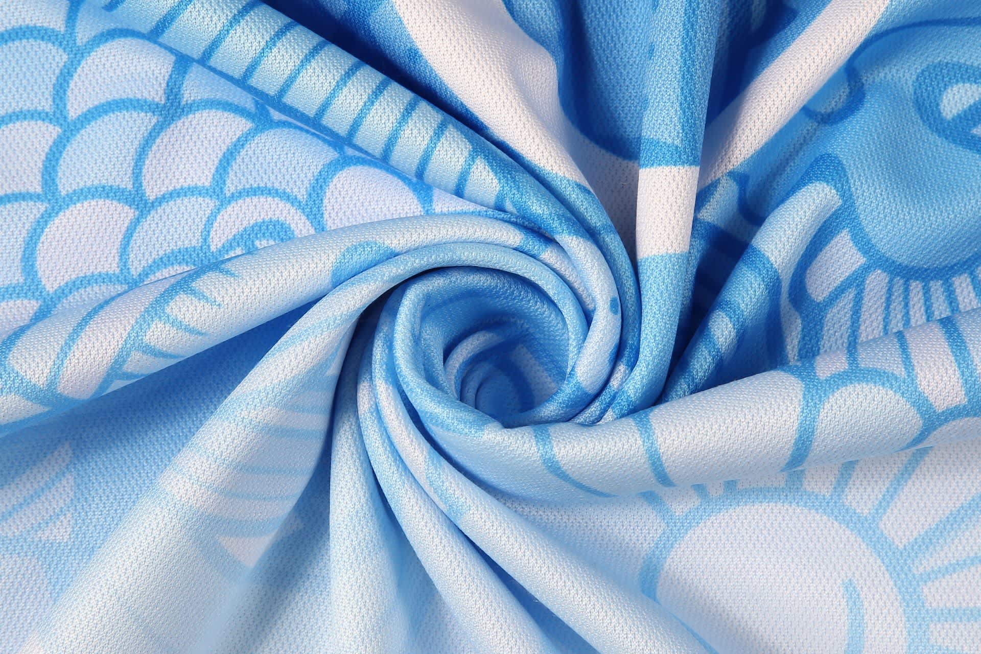 A blue fabric featuring a fish scale pattern, with a swirl design and a smooth texture.