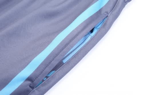 A pair of grey training zip pants with blue stripes and a zippered pocket, designed for sports uniforms.