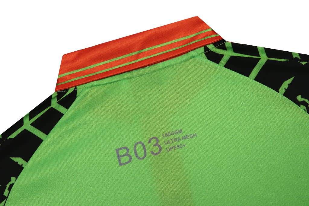 A green and black uniform featuring reflective tape at the collar, with an orange stripe and a logo.