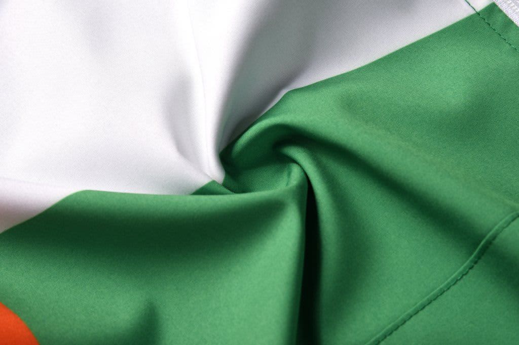 A close-up of a green and white fabric, showcasing smooth, water-repellant material with a logo visible.