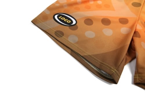 A close-up of an Aboriginal-inspired basketball uniform featuring yellow and orange patterns, with a logo on the side.