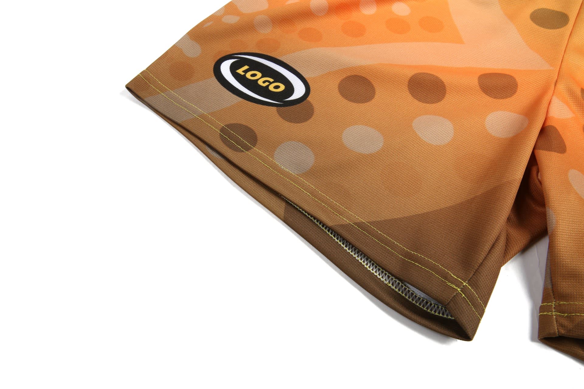 Aboriginal shorts in shades of orange and brown with a circular pattern and a logo.