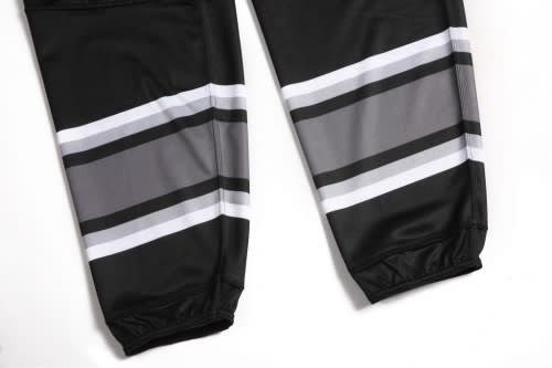 A pair of black racing pants with grey and white stripes, featuring a fitted design and elastic cuffs.