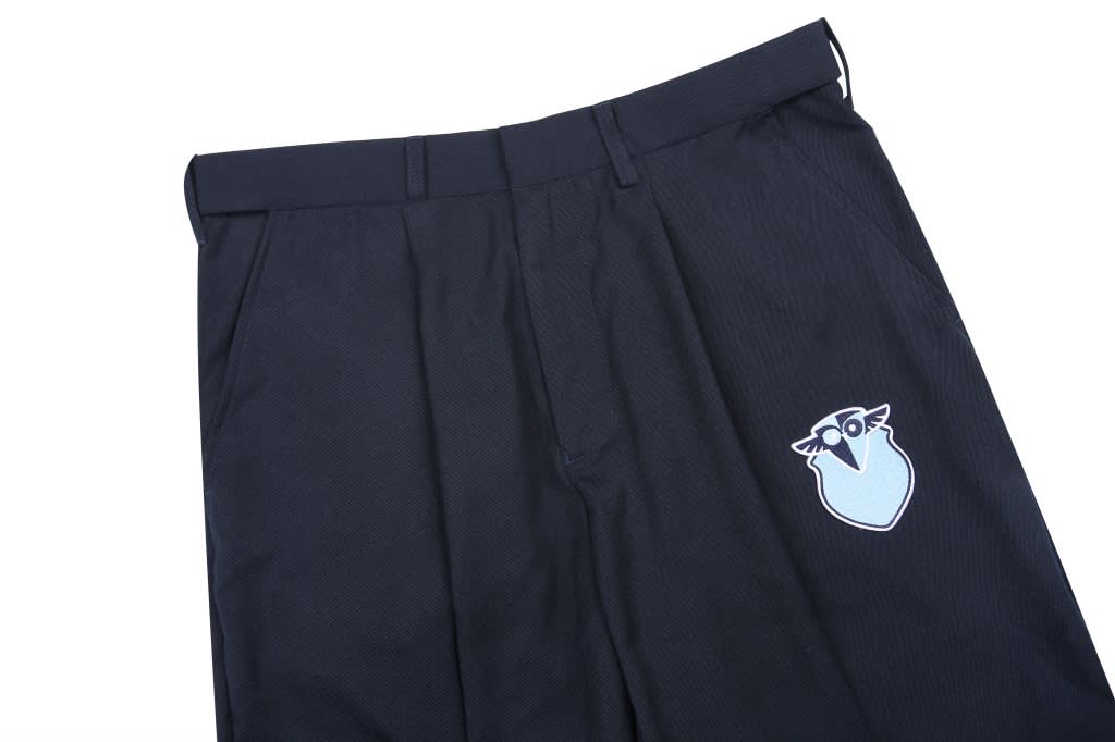 Navy windbreaker pants featuring a logo on the side. Tapered design with a classic cut and pleated details.