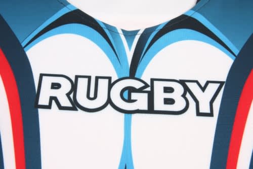 A close-up of a rugby jersey featuring blue, white, and red designs with a logo.