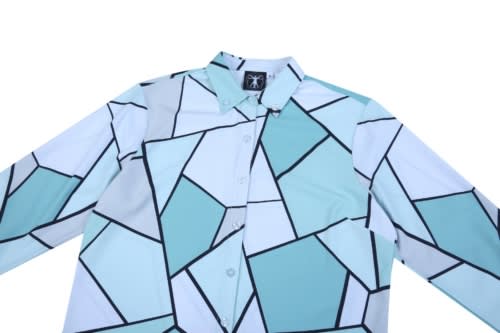 A custom shirt featuring a geometric pattern in shades of light blue and white, with black outlines. It has a logo.