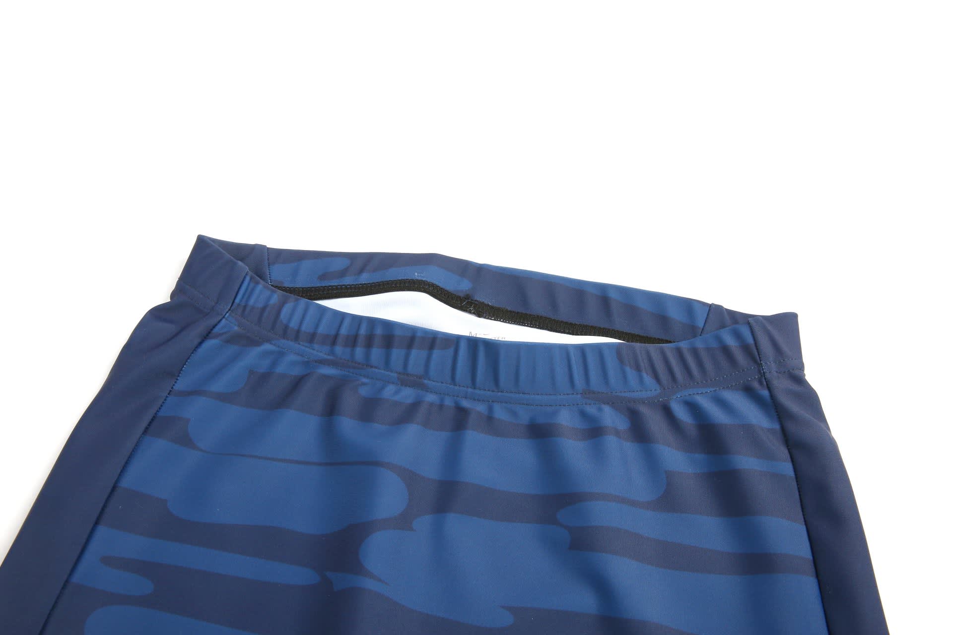TIGHT SHORTS in dark blue with a wave pattern and an elastic waistband, featuring a logo.