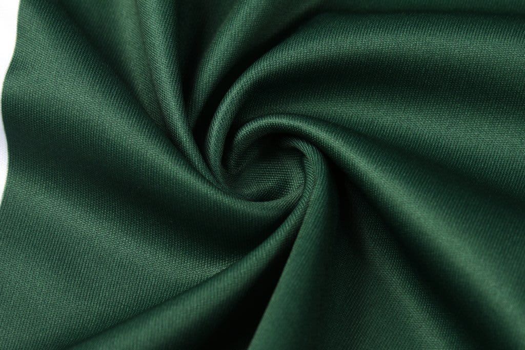 A smooth, dark green fabric displayed in a swirling pattern. It appears soft and has a glossy texture.