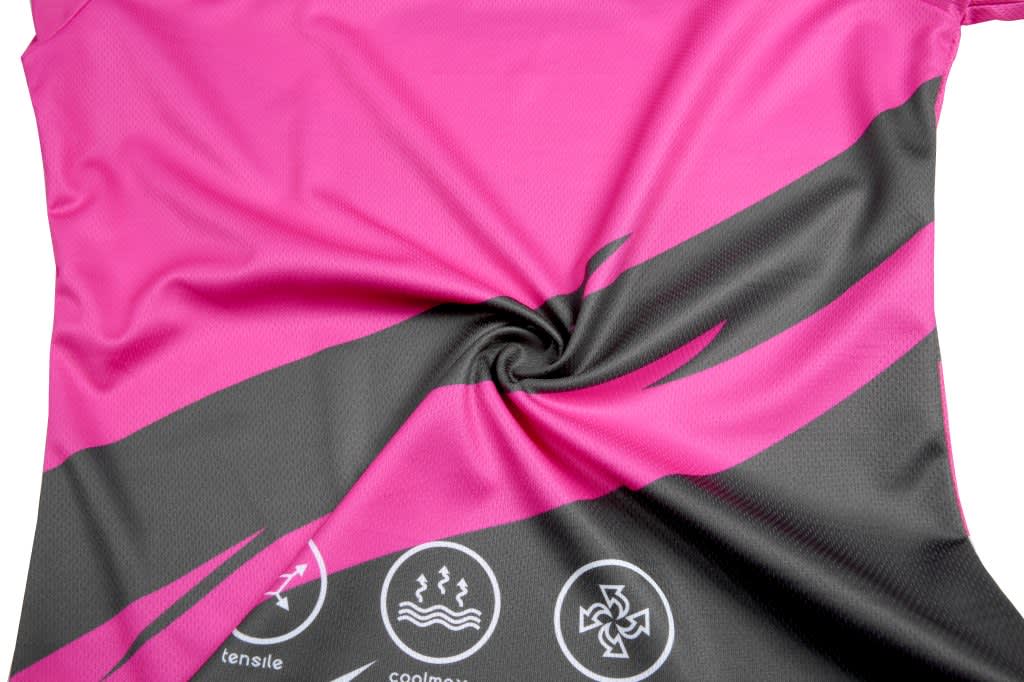 A vibrant pink and black cheerleader uniform fabric featuring logos and a swirling design.