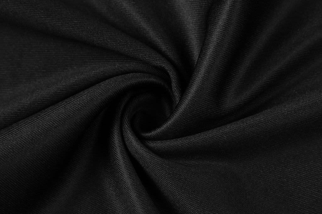 A close-up of black fabric, displaying a smooth texture with a spiral pattern. The image has a subtle sheen.