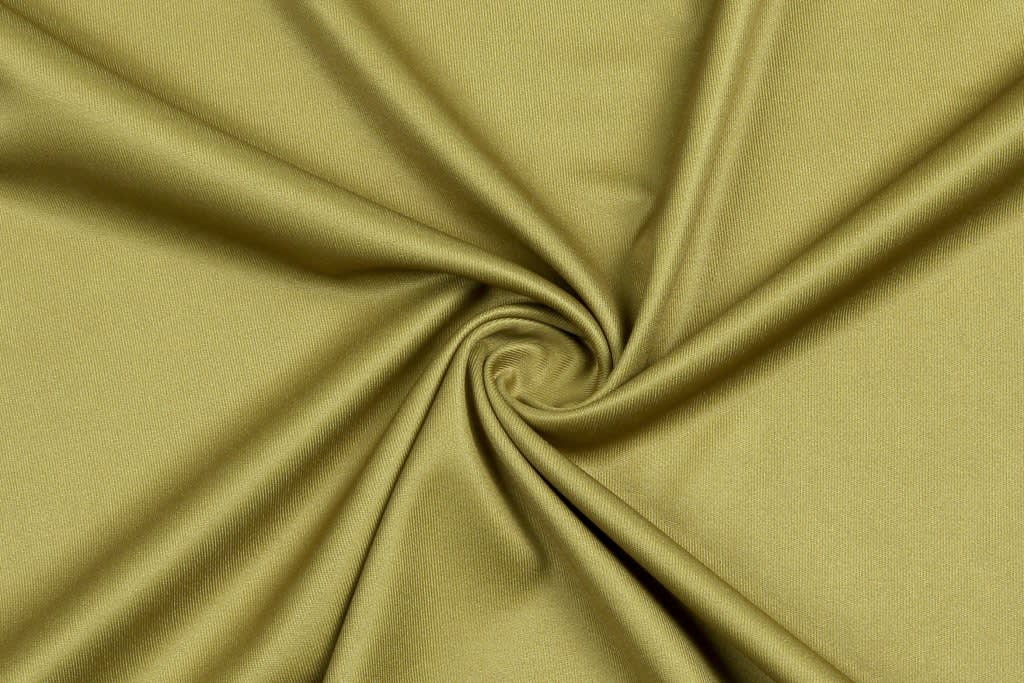 A smooth, olive green fabric intricately folded in a spiralled pattern, featuring a soft texture.