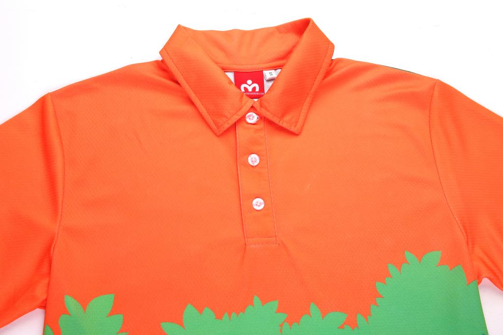 An orange polo shirt with a green foliage design and a collar, featuring buttons and a logo inside the collar.