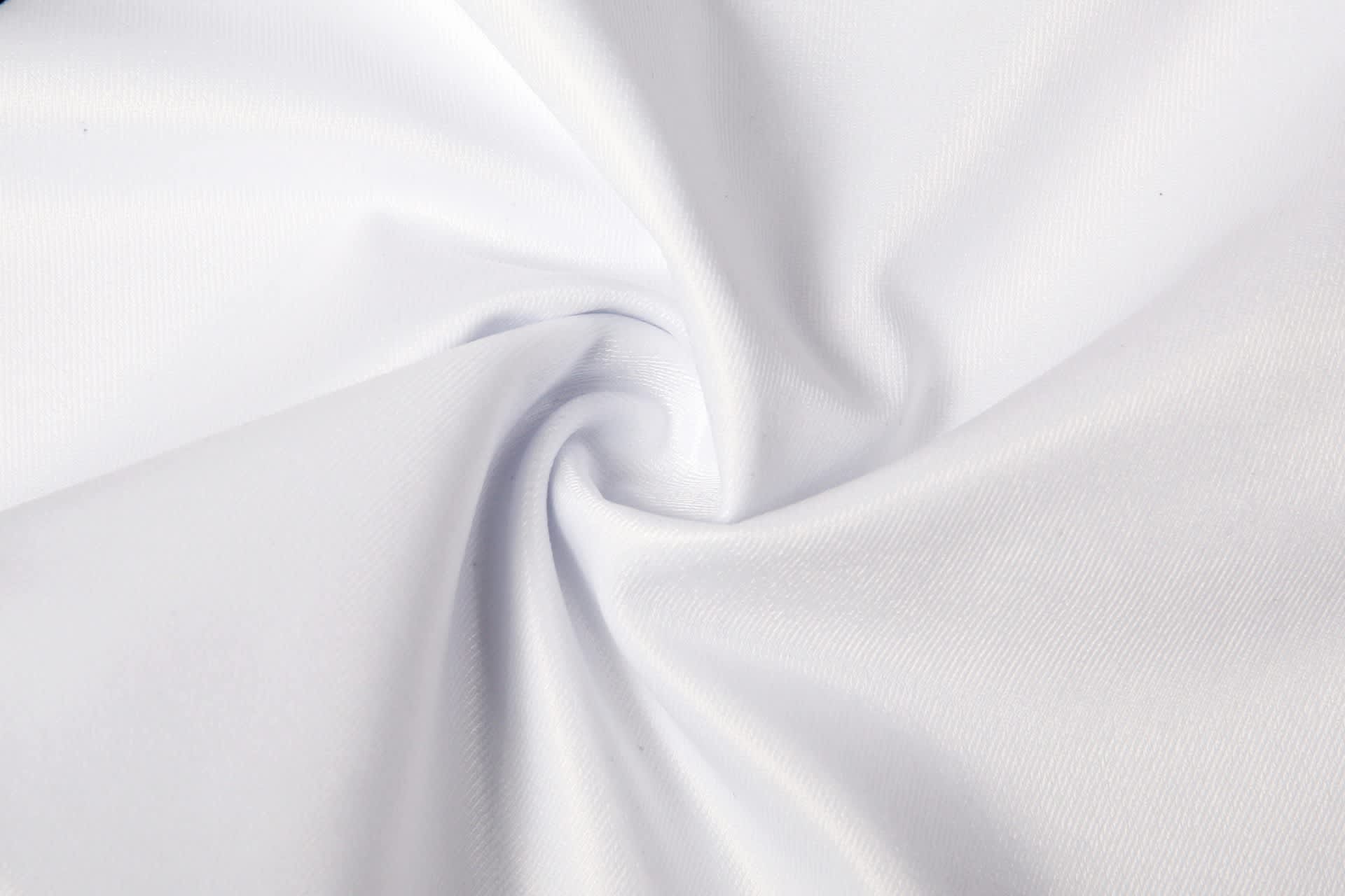 A white fabric with a smooth texture, arranged in a spiral pattern, showcasing its lightweight quality.