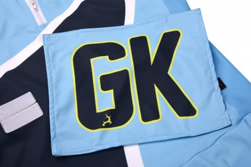 A blue netball bib displaying the initials "GK" in bold, with a logo in the corner.