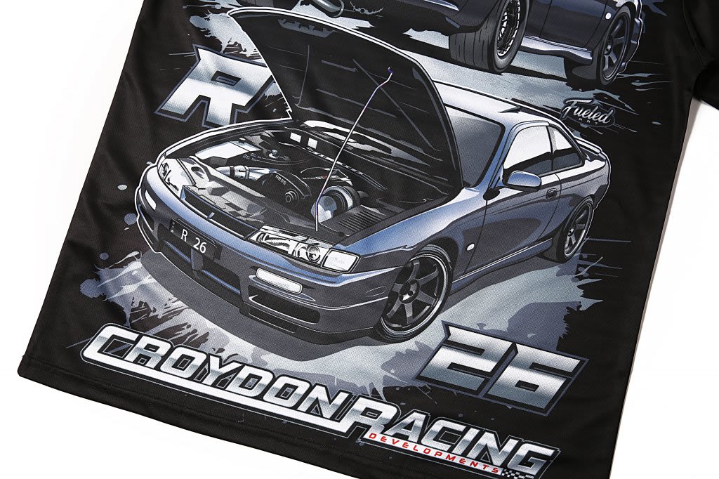 A black polyester t-shirt featuring a detailed graphic of a grey sports car with an open bonnet and a logo present.