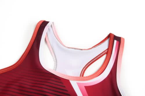 A women's sports uniform featuring a red and pink design, with a racerback style and logo detail.