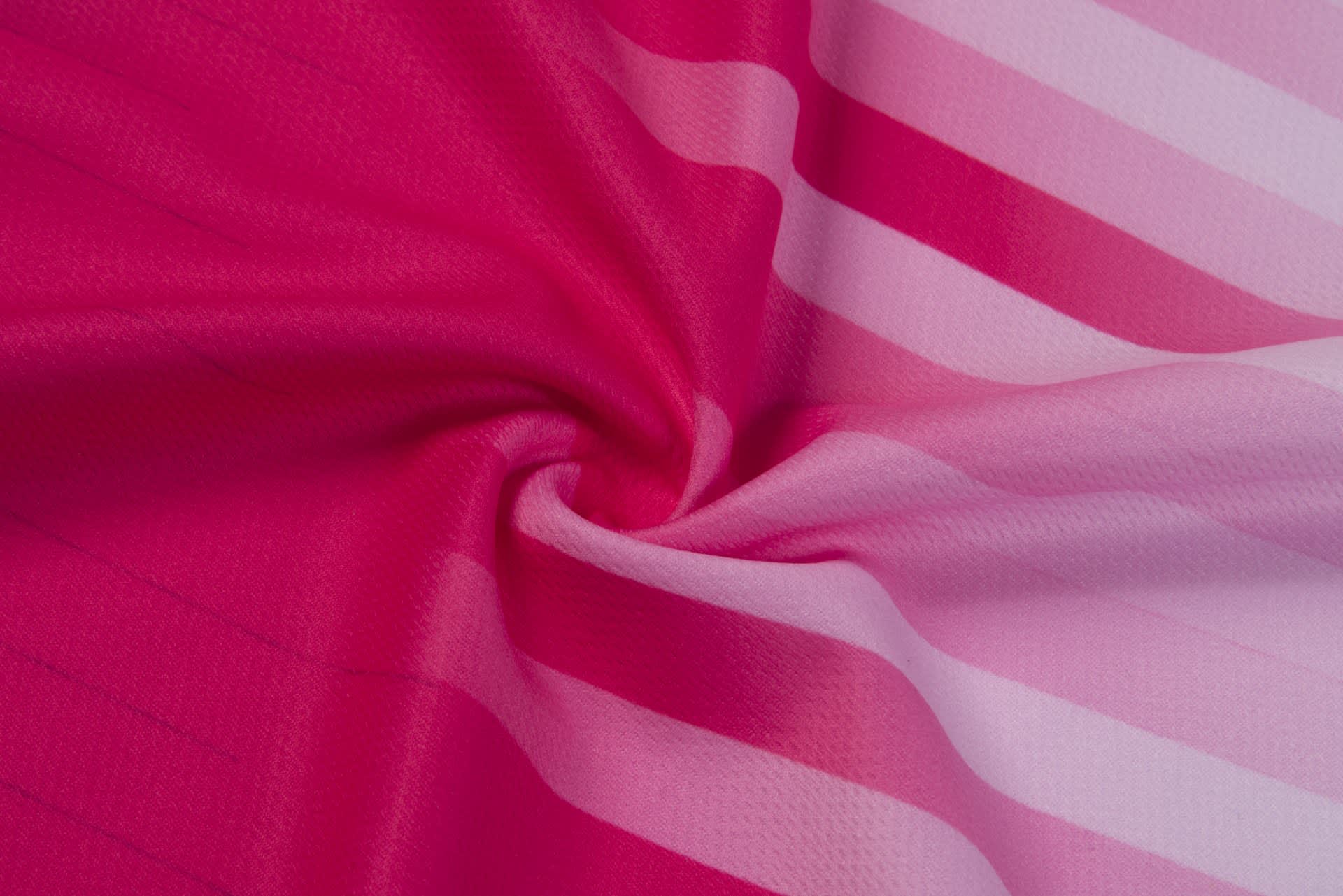 A fabric featuring shades of pink with a striped pattern, showcasing a smooth texture and vibrant colours.