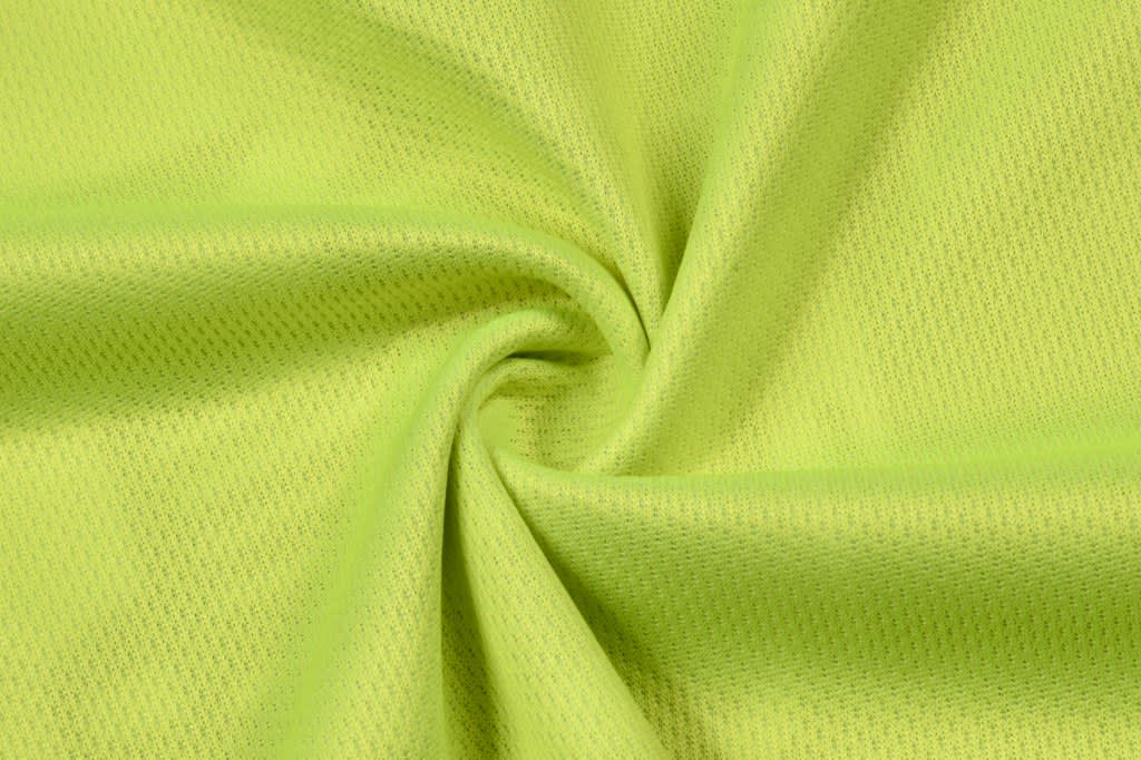 A close-up of bright lime green fabric with a textured, breathable weave, ideal for hi-vis workwear.