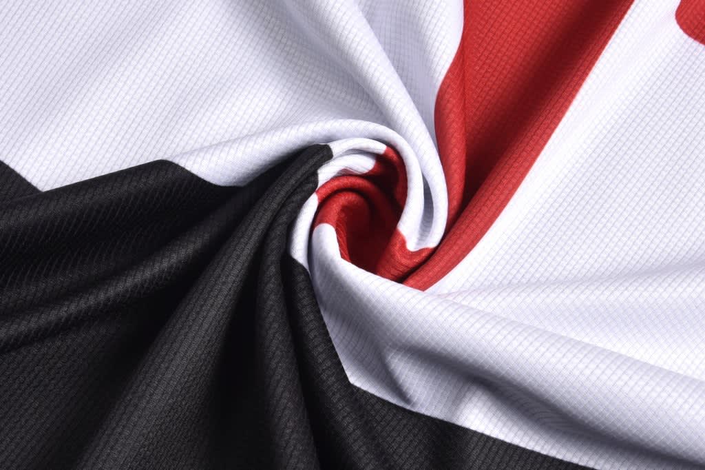A close-up of a tank top hoodie sleeveless vest in black, white, and red fabric, featuring a swirling pattern.